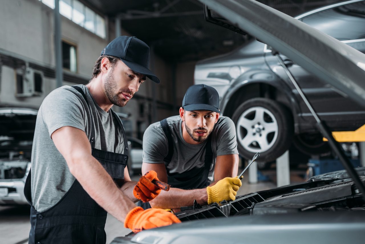 Zwei Mechaniker arbeiten gemeinsam an einem Fahrzeug
